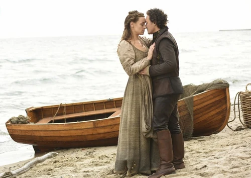 Elizabeth and Gideon embrace along the shoreline