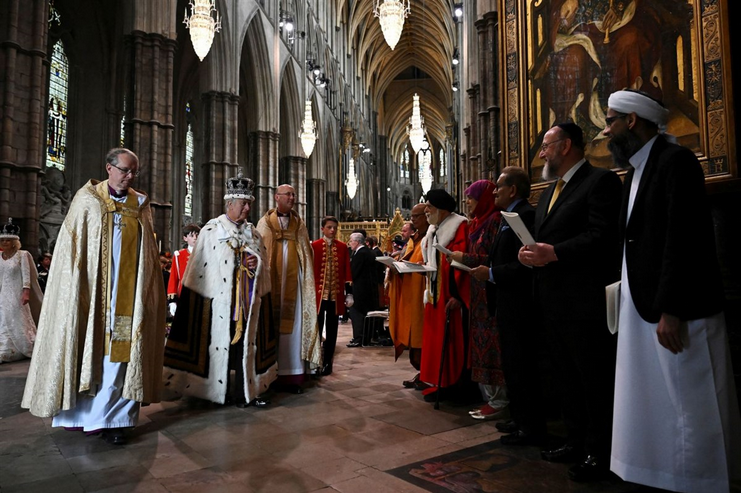 King Charles in coronation regalia is greeted by leaders of multiple faiths.